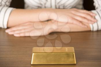 Royalty Free Photo of a Woman's Hands and a Gold Bar