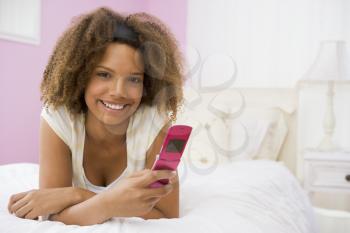 Royalty Free Photo of a Teenage Girl With a Cellphone in Her Room