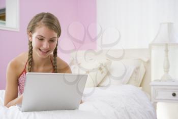 Royalty Free Photo of a Girl in Her Room With a Laptop