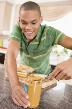 Royalty Free Photo of a Teenager Making a Peanut Butter Sandwich