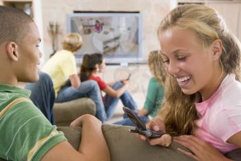 Royalty Free Photo of Kids Watching TV and Using Cellphones