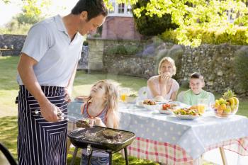 Royalty Free Photo of a Family Enjoying a Barbecue Outside