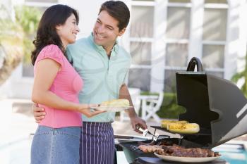 Royalty Free Photo of a Man and Woman Barbecuing