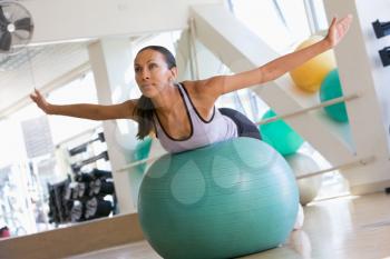 Royalty Free Photo of a Woman Balancing on a Ball at a Gym