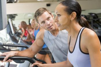 Royalty Free Photo of a Personal Trainer Encouraging a Woman on a Treadmill