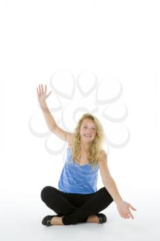 Royalty Free Photo of a Girl Sitting on the Floor With Her Hand Raised