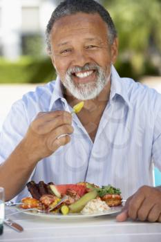 Royalty Free Photo of a Man Eating Outside