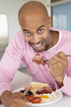 Royalty Free Photo of a Man Eating Bacon and Eggs