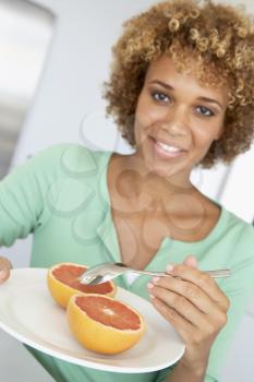 Royalty Free Photo of a Woman Eating Grapefruit