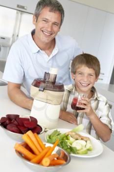 Royalty Free Photo of a Father and Son Making Vegetable Juice