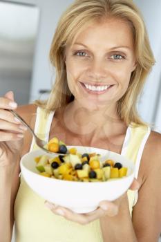 Royalty Free Photo of a Woman Eating Fruit Salad