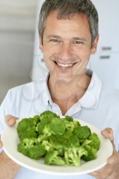 Royalty Free Photo of a Man With a Plate of Broccoli