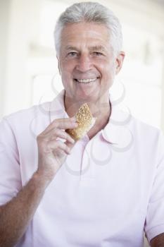 Royalty Free Photo of a Man Eating a Bread Roll