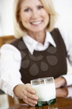 Royalty Free Photo of a Woman Reaching for a Glass of Milk
