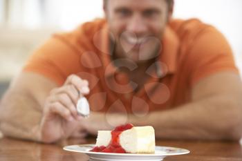 Royalty Free Photo of a Man Eating Cheesecake