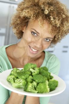 Royalty Free Photo of a Woman With a Plate of Broccoli
