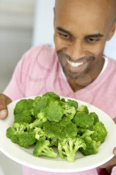Royalty Free Photo of a Man With a Plate of Broccoli
