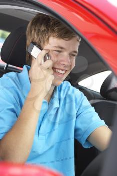 Royalty Free Photo of a Boy in a Car Talking on a Cellphone
