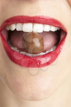Royalty Free Photo of a Mouth With a Chocolate in It