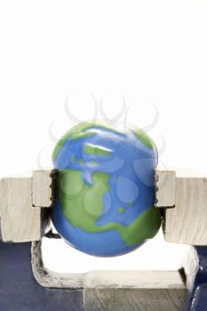Royalty Free Photo of a Model of the Earth Squeezed in a Vice
