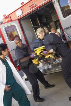 Royalty Free Photo of Paramedics and a Doctor Unloading a Patient