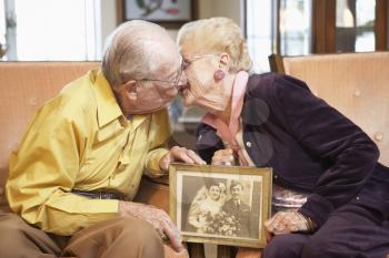 Royalty Free Photo of a Couple Holding a Photo and Kissing