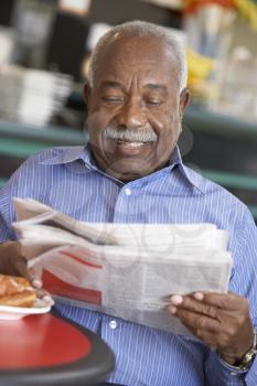 Senior man having morning tea Man Reading a Newspaper