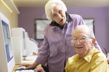 Royalty Free Photo of a Senior Woman Helping a Man at a Computer