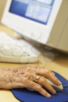Royalty Free Photo of an Older Person's Hand on a Computer Mouse