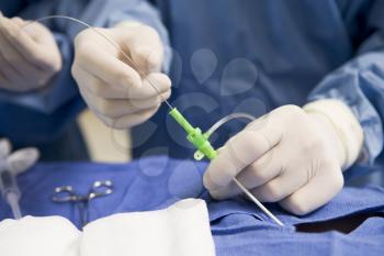 Royalty Free Photo of a Surgeon Inserting a Tube in a Patient