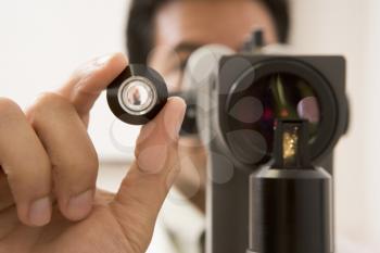 Royalty Free Photo of an Eye Doctor Looking Through a Lens