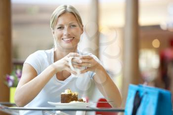 Royalty Free Photo of a Woman Having a Piece of Cake at a Mall