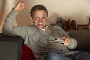 Royalty Free Photo of a Man Cheering an Watching TV