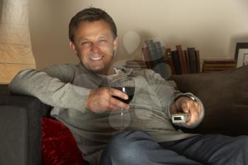 Royalty Free Photo of a Man With a Glass of Wine Watching TV