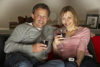 Royalty Free Photo of a Couple Drinking Wine and Watching TV
