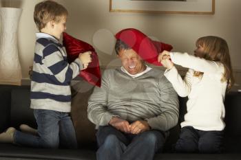 Royalty Free Photo of Children and a Father Having a Pillow Fight