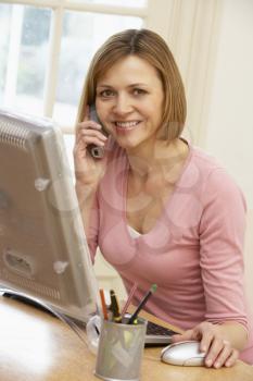 Royalty Free Photo of a Woman at the Computer on the Telephone