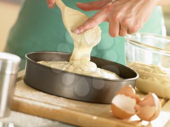 Royalty Free Photo of Pouring Cake Batter Into a Pan