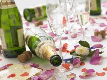 Royalty Free Photo of Empty Wine Bottles Among Rose Petals