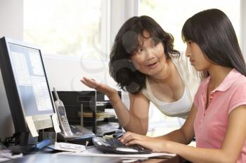 Royalty Free Photo of a Woman Watching Her Daughter at the Computer