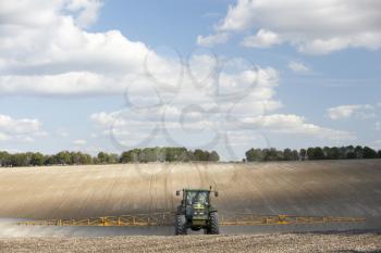 Royalty Free Photo of a Tractor Spraying a Field