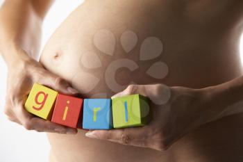 Royalty Free Photo of a Pregnant Woman Holding the Word Girl