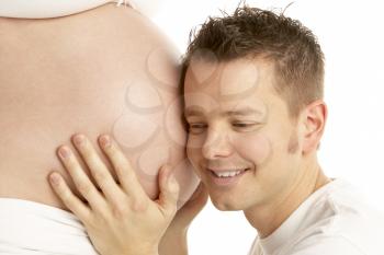 Royalty Free Photo of a Man Listening to a Pregnant Woman's Belly