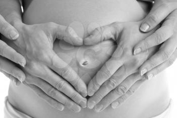 Royalty Free Photo of a Husband's Hands Forming a Heart Over the Mother's Belly