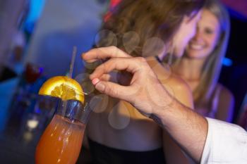 Royalty Free Photo of a Man Drugging a Woman's Drink