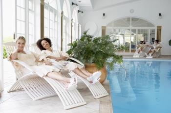 Royalty Free Photo of Women Relaxing Around a Pool