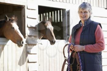 Royalty Free Photo of a Woman Outside a Horse Stable