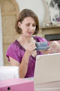 Royalty Free Photo of a Woman at a Desk With a Coffee