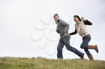 Royalty Free Photo of a Couple Running in a Park
