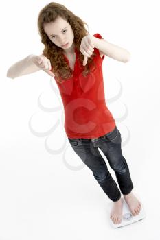 Royalty Free Photo of a Girl on Bathroom Scales Giving a Thumbs Down